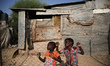 Palestinian children stand outside their home, a hovel, amid poor living conditions in the...