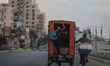 A Palestinian man rides in the back of a tuk-tuk on a street in Gaza City on August 22, 20...
