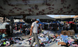 Palestinians sifts through used clothes and items at the weekly flea market in the Nusseir...
