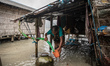 A woman tries to fill up her mag from the rainwater which comes from the pet bottle-made p...
