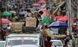 A man puts boxes filled with daily goods on a passenger vehicle in a market in Baramulla J...