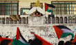Palestinians look out through the window of their house to a march calling for an end to P...