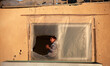 Palestinian girl look from the window of her family's home in the Shati refugee camp in Ga...