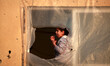 Palestinian girl look from the window of her family's home in the Shati refugee camp in Ga...