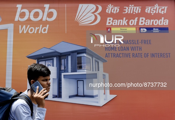 A boy on phone walks past a Bank Of Baroda billboard in Mumbai, India, 29 August, 2022. India's Bank of Baroda planning to raise Rs 5 billio...