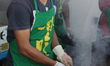 Chinese cooks barbecue lamb kabobs on small grills during an all-night Chinese market in M...