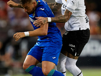 Portu (L) of Getafe CF competes for the ball with Samu Castillejo of Valencia CF during the LaLiga Santander match between Valencia CF and G...