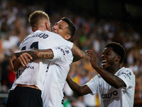 Samu Castillejo (L) of Valencia CF celebrates after scoring their side's third goal with his teammates Marcos Andre (C) and Yunus Musah duri...
