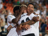 Samu Castillejo (C) of Valencia CF celebrates after scoring their side's third goal with his teammates Marcos Andre (R) and Yunus Musah duri...