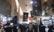 Shi'ite pilgrims walk under two religious flags in a bazaar (Market) in the Iraqi holy cit...