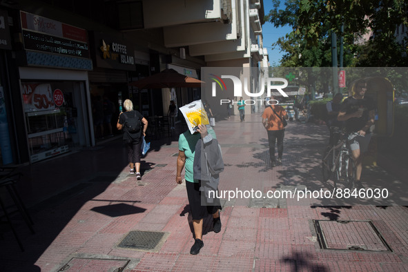 A woman puts the newspaper for protection from the sun in the center of Athens, Greece on September 14, 2022. 