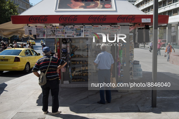 Two men are looking newspapers on a kiosk in the center of Athens, Greece on September 14, 2022. 