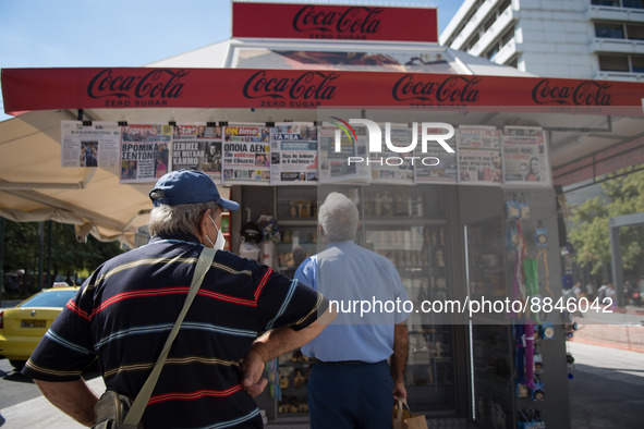 Two men are looking newspapers on a kiosk in the center of Athens, Greece on September 14, 2022. 