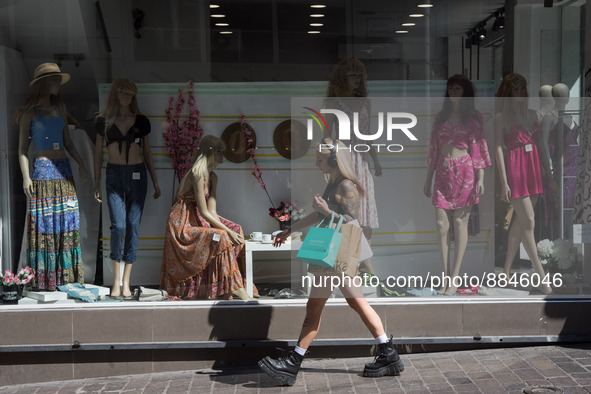 A woman is passing in front of a store at Ermou street in the center of Athens, Greece on September 14, 2022. 