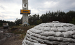 IZIUM, UKRAINE - SEPTEMBER 15, 2022 - A pile of sandbags is pictured near a roadsign en ro...