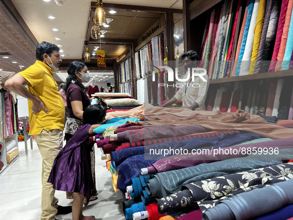 Customers look at cloth to be made into ladies churidar suits and sarees at a textile shop in Thiruvananthapuram, Kerala, India, on May 22,...