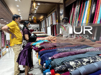 Customers look at cloth to be made into ladies churidar suits and sarees at a textile shop in Thiruvananthapuram, Kerala, India, on May 22,...
