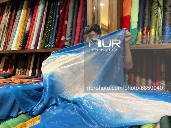 Salesman measures cloth for a customer to be used for a saree at a textile shop in Thiruvananthapuram, Kerala, India, on May 22, 2022. 