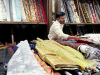 Salesman cuts cloth for a customer to be made into ladies churidar suits at a textile shop in Thiruvananthapuram, Kerala, India, on May 22,...