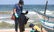 A child collects garbage with his mother on the beach at Dehiwala to coincide with World C...