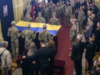 Relatives, friends and brothers-in-arms attend a funeral ceremony for volunteer soldier Oleksandr Shapoval, a famous ballet dancer and soloi...