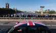 LONDON, UNITED KINGDOM - SEPTEMBER 17, 2022: A taxi with a Union Jack flag on the roof dri...