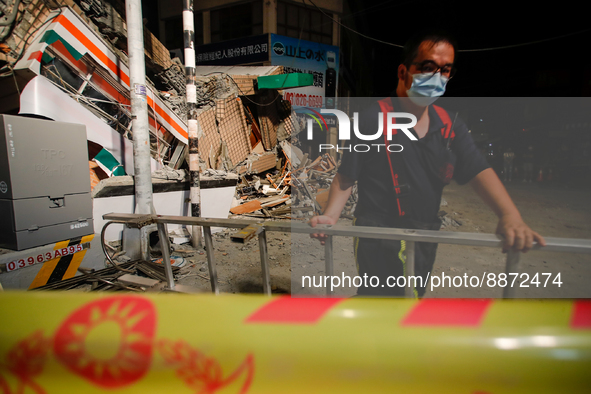 A rescuer with a ladder outside the wreckage of a collapsed residential building after a magnitude 6.8 earthquake strikes Taiwan, in Yuli, H...