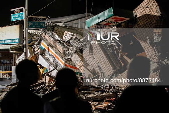 Residents wait outside the wreckage of a collapsed residential building after a magnitude 6.8 earthquake strikes Taiwan, in Yuli, Hualien, T...