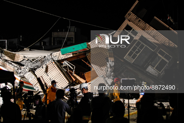 Rescuers with equipment walk past the wreckage of a collapsed residential building after a magnitude 6.8 earthquake strikes Taiwan, in Yuli,...