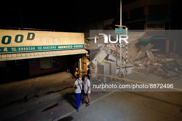 People take selfies with the wreckage of a collapsed residential building after a magnitude 6.8 earthquake strikes Taiwan, in Yuli, Hualien,...