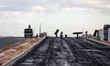 Palestinian workers lay asphalt as a Al-Rashid street is paved in North Gaza Strip, on Sep...