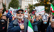 A man sings, hand over heart, duriing a vigil for Mahsa Amini, the young woman who died la...