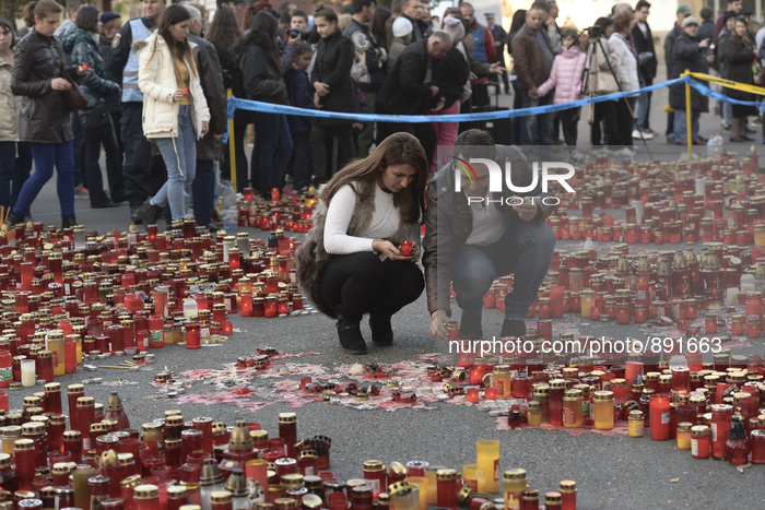 Thousands of flowers and candles in front of the Colectiv nightclub