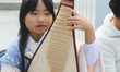 Chinese girl plays a classical song on the Pipa (Chinese lute) during the Community Crime...