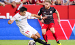 Iker Muniain of Athletic Club competes for the ball with Marcos Acuna of Sevilla FC during...