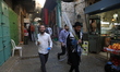 Orthodox Jewish People walk in an alley in the Old City of Jerusalem. It is the Holiday of...