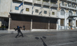 A protester throws a molotov cocktail at riot police in central Athens during a general st...