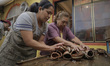 Members of the Mejía family arrange clay moulds for making sugar skulls inside a home in X...