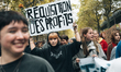 A young protester holds above her head a sign with the slogan "Requisition of profits" dur...