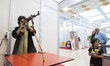 An Iranians woman practices shooting with a shooting simulator made in Iran at a shooting...