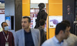 Iranian visitors walk past a mannequin decorated with military safety equipments at the bo...