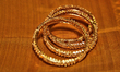 Elegant gold bangles on the silk cloth of an Indian saree in Brampton, Ontario, Canada. 