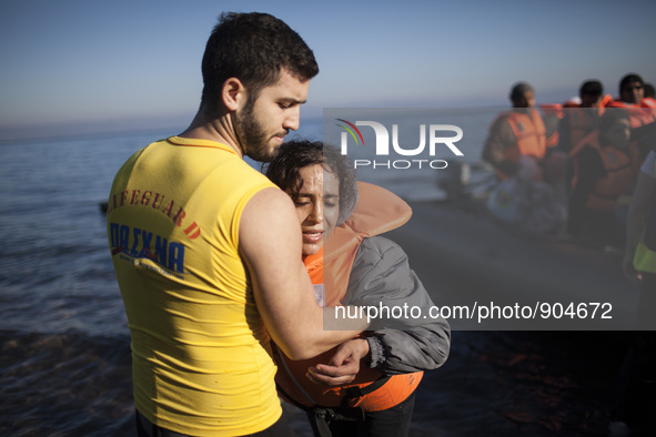 A man helps a woman as refugees and migrants riding a dinghy reach the shores of the Greek island of Lesbos after crossing the Aegean Sea fr...