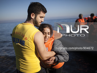 A man helps a woman as refugees and migrants riding a dinghy reach the shores of the Greek island of Lesbos after crossing the Aegean Sea fr...