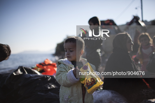 A child stands as refugees and migrants riding a dinghy reach the shores of the Greek island of Lesbos after crossing the Aegean Sea from Tu...