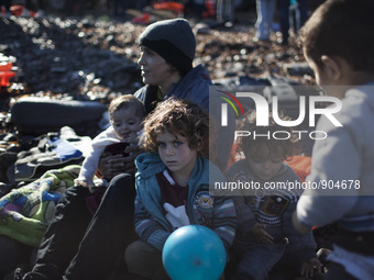A mother and her children rest as refugees and migrants riding a dinghy reach the shores of the Greek island of Lesbos after crossing the Ae...