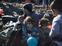 A mother and her children rest as refugees and migrants riding a dinghy reach the shores of the Greek island of Lesbos after crossing the Ae...