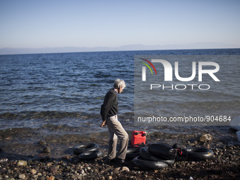A man stands after refugees and migrants riding a dinghy reached the shores of the Greek island of Lesbos after crossing the Aegean Sea from...