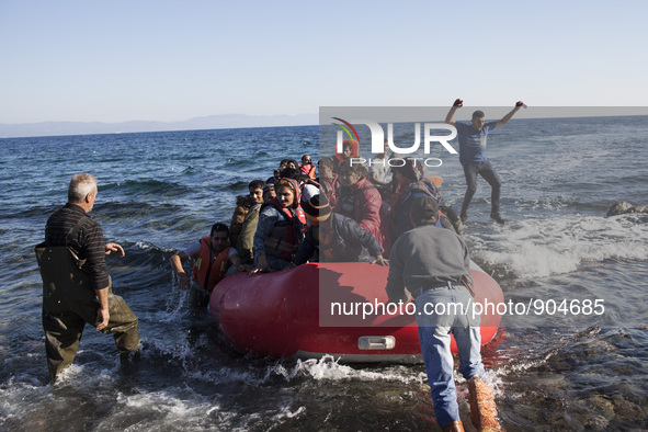 Migrants riding a dinghy reach the shores of the Greek island of Lesbos after crossing the Aegean Sea from Turkey on November 13, 2015. 