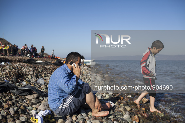 A man makes a call moments after refugees and migrants riding a dinghy reached the shores of the Greek island of Lesbos after crossing the A...